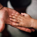 Child's hand holing Presumed Parents hand